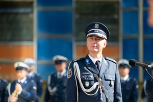 Na zdjęciu policjant stojący obok mikrofonu