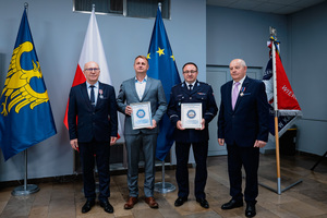 Na zdjęciu policjant oraz osoby wyróżnione.