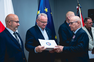 Na zdjęciu osoba podczas odbierania wyróżnienia.