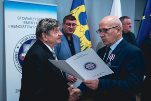 Na zdjęciu osoba odbierająca wyróżnienie.