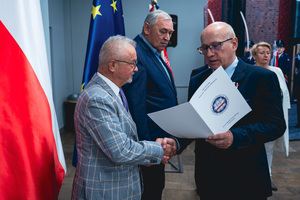 Na zdjęciu osoba odbierająca wyróżnienie.