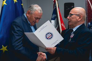 Na zdjęciu osoba odbierająca wyróżnienie.