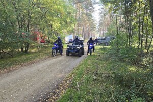policjant na quadzie, przy nim dwaj policjanci na motocyklach, za nimi radiowozy