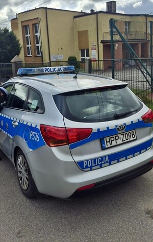 radiowóz przed budynkiem szkoły
