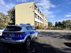 radiowóz przed budynkiem szkoły