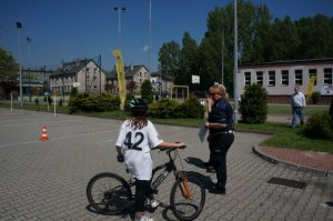 Policjantka ruchu drogowego z młodą uczestniczką finału stojącą przy rowerze