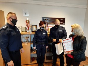 Komendant Powiatowy Policji w Będzinie wraz z umundurowanymi policjantami i wykonawca maskotek Anna Cieślik