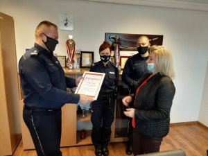 Komendant Powiatowy Policji w Będzinie przekazuje dyplom wykonawcy maskotek - Anna Cieślik