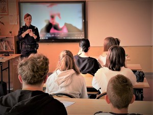 Na zdjęciu policjantka omawia przedstawiony dla uczniów film dotyczący uzależnień.