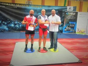 Na zdjęciu 3 mężczyzn podczas wręczania nagród w zawodach siłowych.
