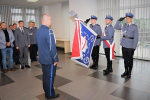 Na zdjęciu Komendant Powiatowy Policji w Będzinie stoi przed sztandarem.