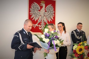 Zdjęcie, na którym kobieta wręcza kwiaty nowemu Komendantowi Powiatowemu Policji w Będzinie.