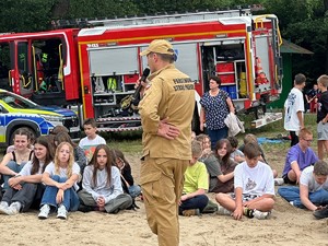 Na zdjęciu strażak przemawia do dzieci.
