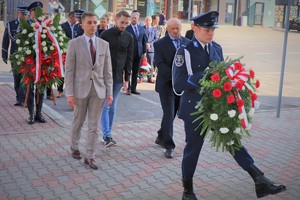 Na zdjęciu tata śp. Grzegorza Załogi wraz z rodziną składa kwiaty pod tablicą pamiątkową.