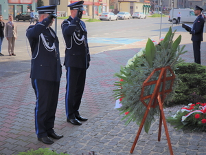 Na zdjęciu Zastępca Komendanta Wojewódzkiego Policji w Katowicach oraz Komendant Powiatowy Policji w Będzinie oddają honor pod tablicą pamiątkową przy złożeniu kwiatów.