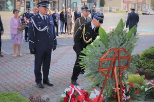 Na zdjęciu przedstawiciele służb mundurowych składają kwiaty pod obeliskiem .