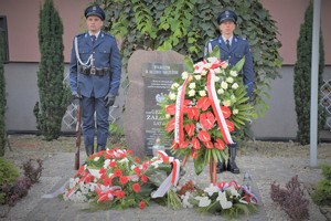 Na zdjęciu policjanci przy tablicy pamiątkowej oraz kwiaty.