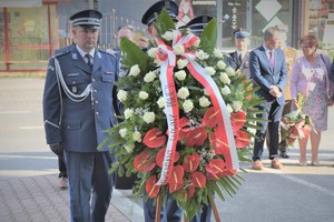 Na zdjęciu policjant trzyma wieniec od Komendanta Głównego Policji, za nim idą Komendanci.