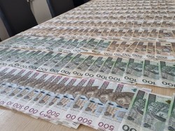 Na stole zabezpieczone przez policjantów banknoty.
