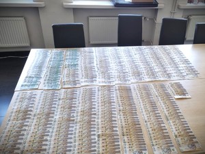 Na zdjęciu widoczne banknoty rozłożone na stole.