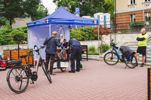 Zdjęcie na którym widzimy rowerzystów, którzy podchodzą do policjantów, żeby znakować swoje rowery.