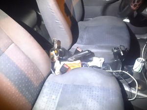Na zdjęciu wnętrze samochodu, na którym widzimy otwarte piwo pomiędzy siedzeniami.