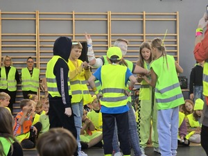 Na zdjęciu uczniowie bandażują kobietę.