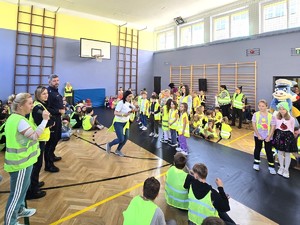 Zdjęcie na grupę uczniów i dorosłych podczas konkursu związanego z odblaskami.
