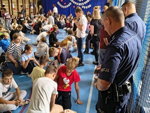 Na zdjęciu policjanci i uczniowie na sali gimnastycznej podczas resuscytacji.
