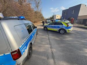 Na zdjęciu dwa radiowozy policyjne zastawiający drogę innemu pojazdowi.