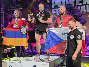 Na zdjęciu 3 mężczyzn na podium zawodów siłowych.