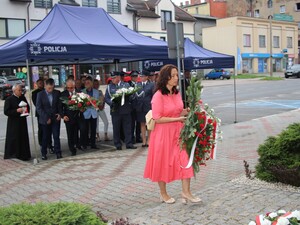 Pani Dyrektor szpitala MSWiA składa kwiaty pod pomnikiem, przed budynkiem komendy.