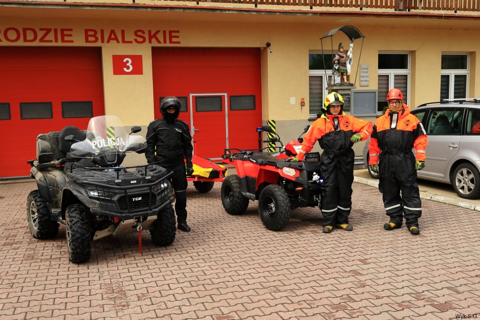 Policjanci i strażacy ochotnicy stoją pod OSP w Międzybrodziu Bialskim