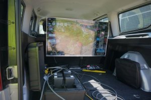 Wnętrze pojazdu obsługującego policyjnego drona, ekran telewizora i osprzęt bezzałogowego statku powietrznego policji — drona DJI Matrice 300 RTK.