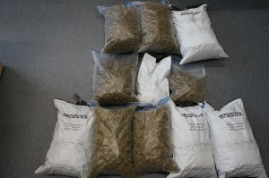 Marihuana zabezpieczona przez Policję spakowana w torbach foliowych ułożona na posadzce pokoju służbowego.