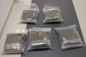 Marihuana zabezpieczona przez Policję spakowana w torbach foliowych ułożona na posadzce pokoju służbowego.