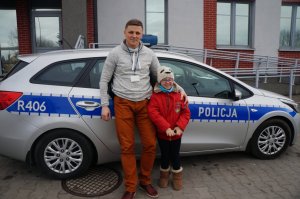 Policjant i dziewczynka przy radiowozie