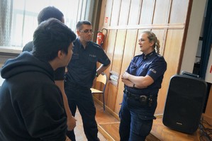 Na auli Powiatowego Zespołu Szkół w Bieruniu dwoje policjantów stoi rozmawiając z uczniami