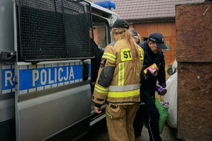Na zdjęciu policjanci i strażacy wyciągają z radiowozu dary dla zwierząt