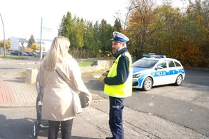 Na zdjęciu widzimy policjanta jak daje odblask