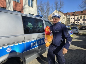 Na zdjęciu widzimy policjanta w czasie przekazywania darów dla przytuliska