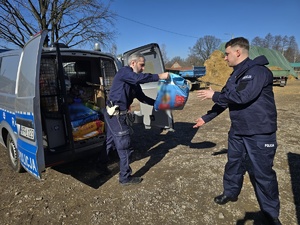 Na zdjęciu widzimy policjantów w czasie przekazywania darów dla przytuliska