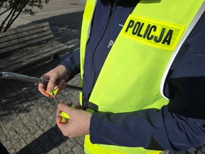 Na zdjęciu widzimy policjanta dającego odblask