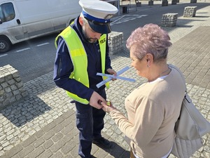 Na zdjęciu widzimy policjanta dającego odblask