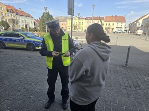 Na zdjęciu widzimy policjanta dającego odblask