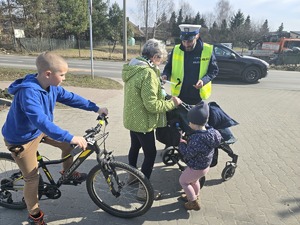 Na zdjęciu widzimy policjanta dającego odblask