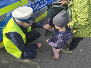 Na zdjęciu widzimy policjanta dającego odblask