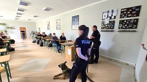 Na zdjęciu widzimy policjantów i psa służbowego  w czasie profilaktyki