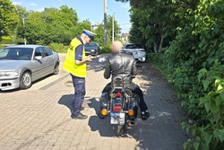 Na zdjęciu widzimy policjanta oraz motocyklistę w trakcie kontroli drogowej