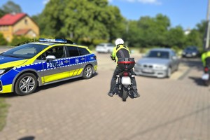 Na zdjęciu widzimy policjanta oraz motocyklistę w trakcie kontroli drogowej
